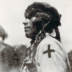 Photogaph if Shuar man wearing beetlewing-cover ear ornaments