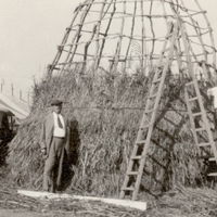 Heye next to a Chumash grass lodge