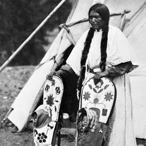 Photograph of woman with twin daughters in their cradleboards