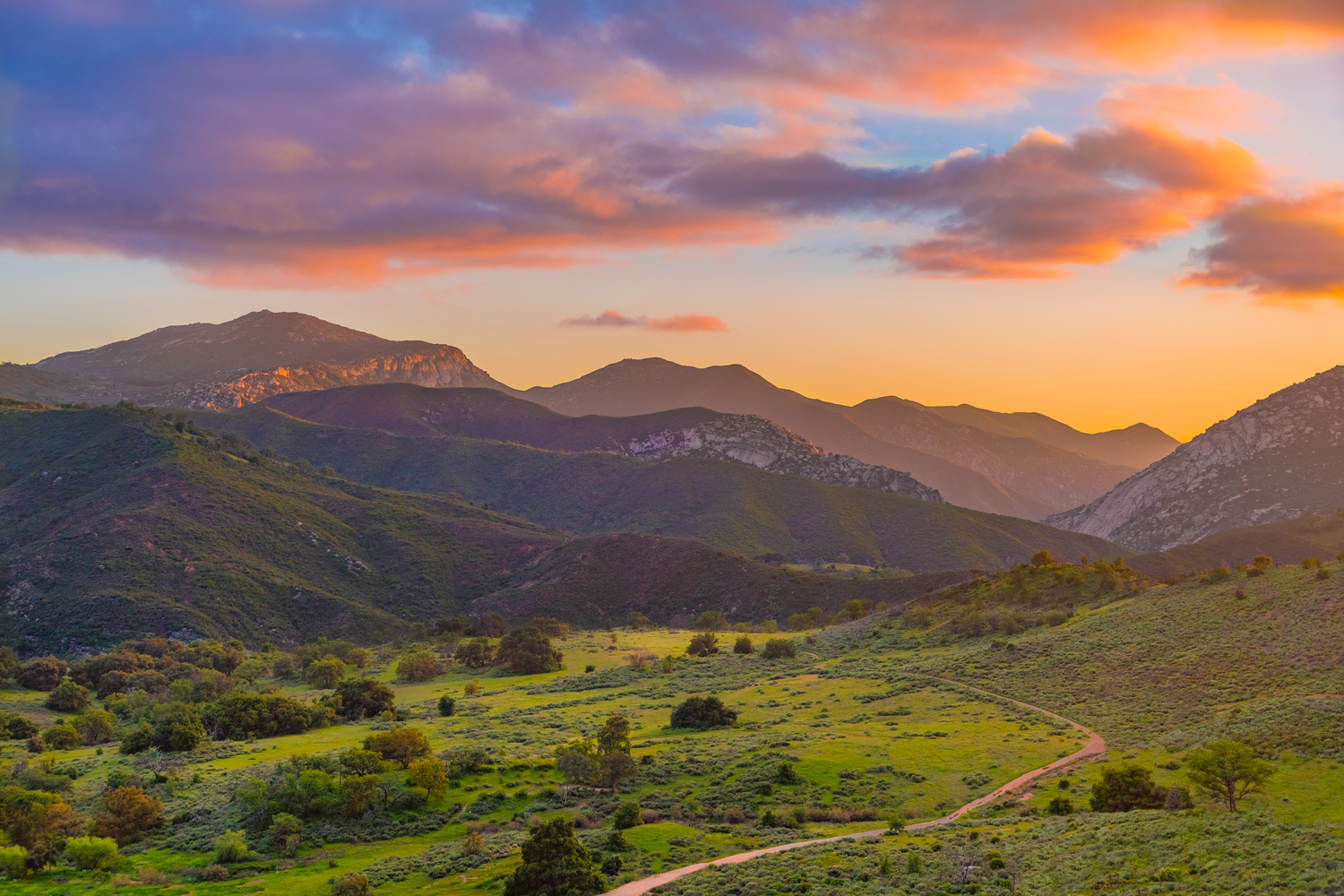Sunset over a green valley and Palomar Mountain, a sacred mountain in Luiseño homeland, in present-day San Diego County.