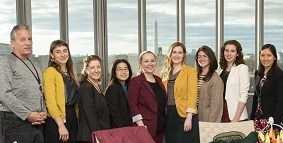 Group of people standing behind a table