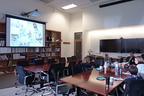 People sitting at a table with a screen in the background