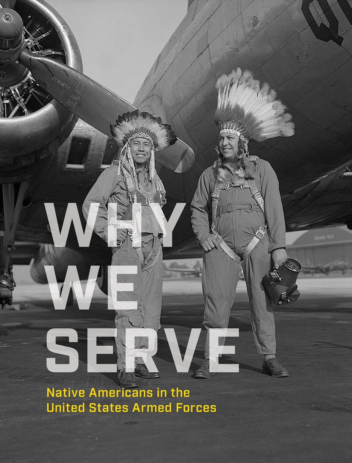 The cover of the book “Why We Serve” featuring two airman, wearing headdresses, in front of a plane