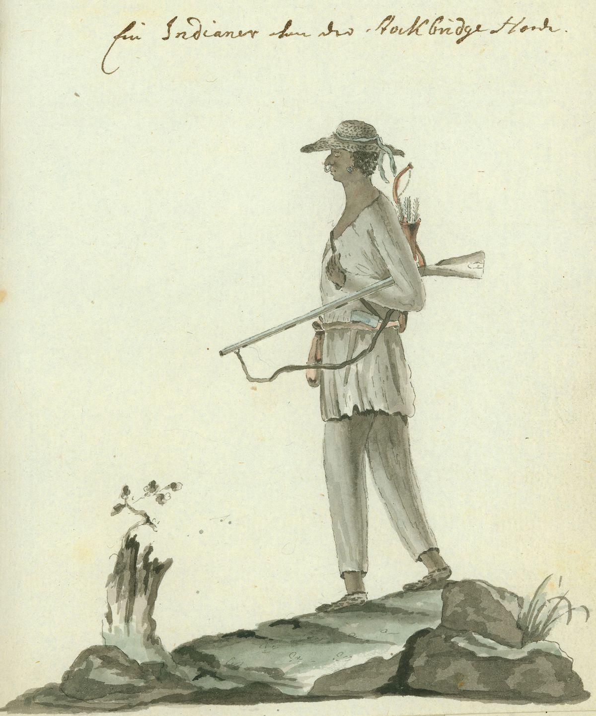 Side profile of a man standing on a small boulder while carrying a rifle